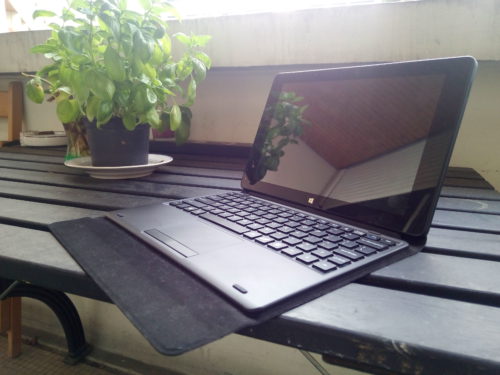 Une tablette-clavier Cube iWork 10 Ultimate ouverte sur un bureau, à côté d'une plante verte