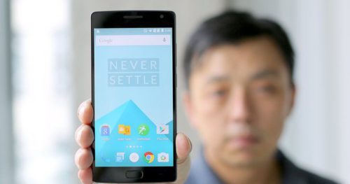 Un homme tenant un OnePlus 3 de face, écran affichant la devise Never Settle