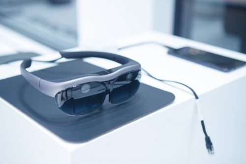 Des lunettes de réalité augmentée Vivo posées sur un bureau, reliées par un câble