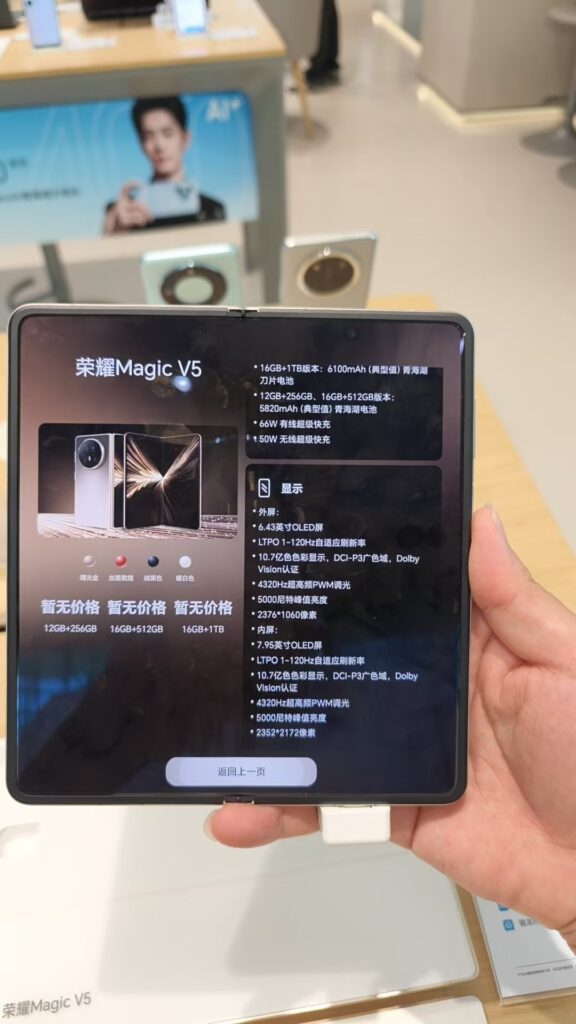 Une main tenant le Honor Magic V5 ouvert dans un magasin, écran affichant une fiche technique en chinois