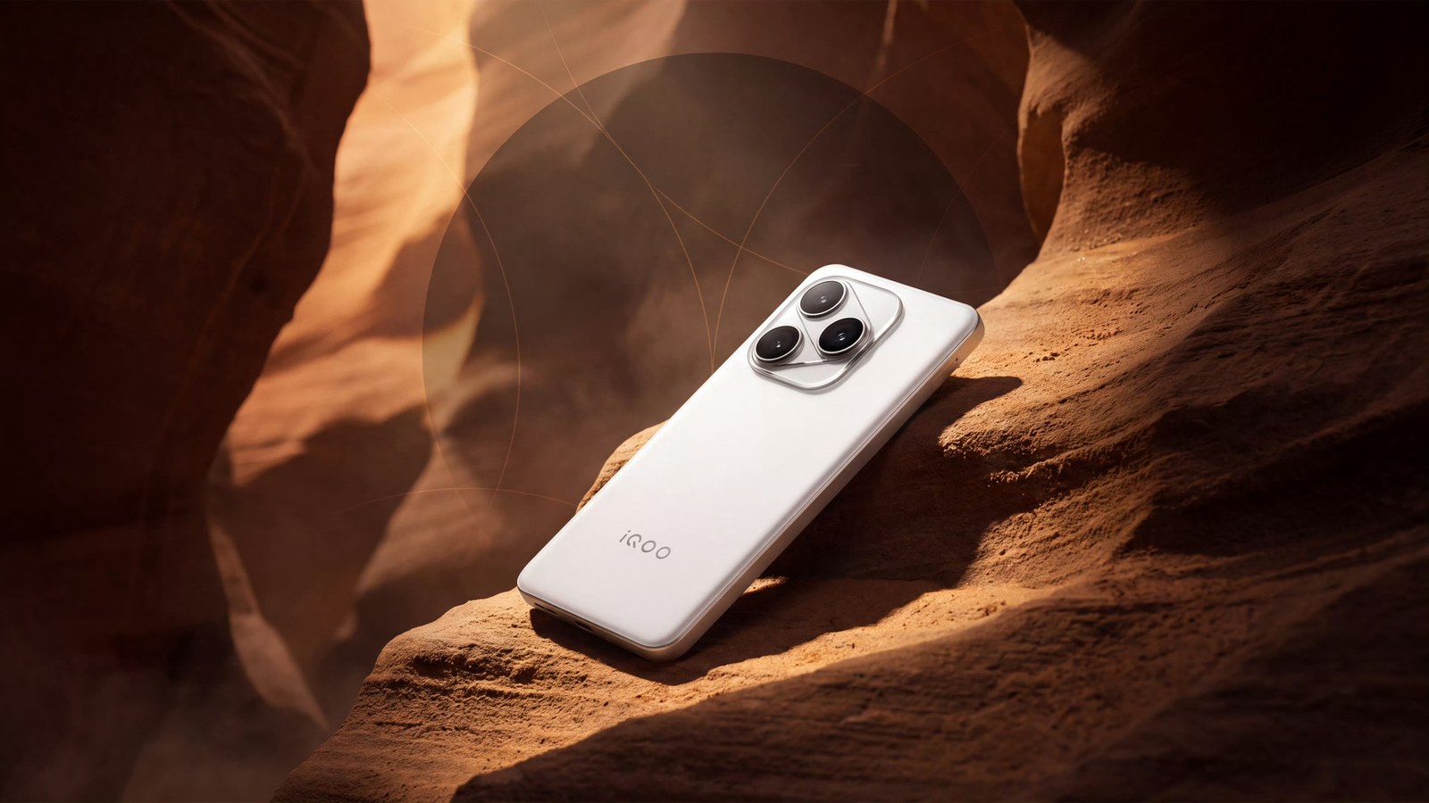 Smartphone blanc posé de dos sur une paroi de roche ocre, dans un canyon étroit traversé par une lumière rasante